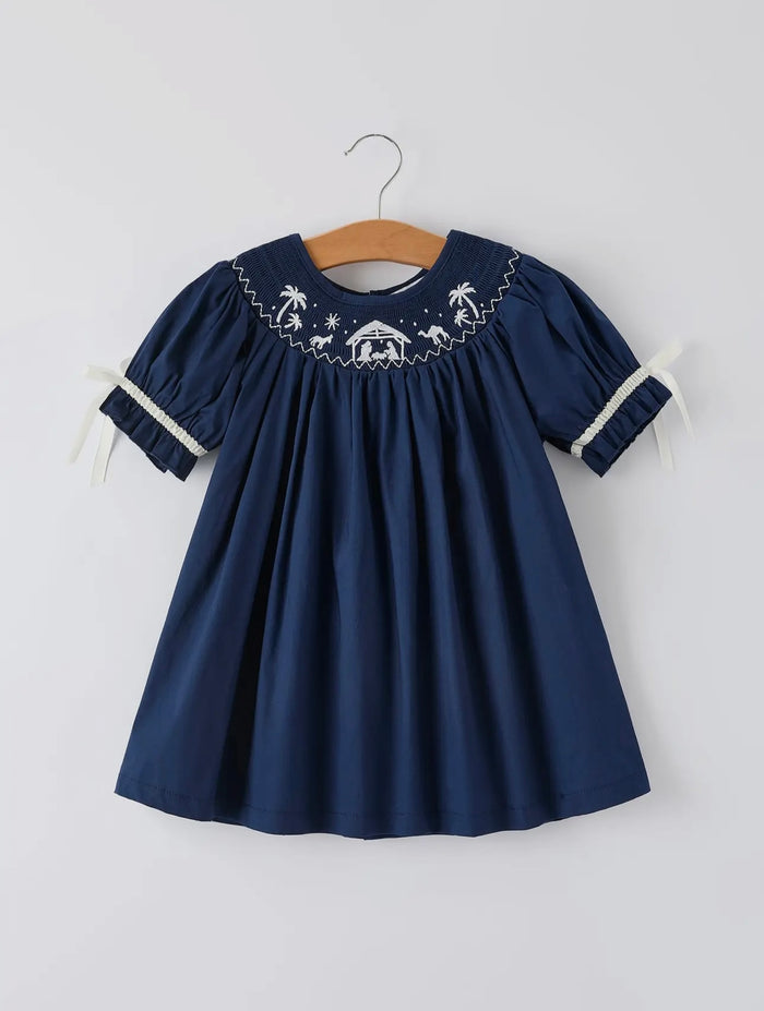 Navy blue dress with white embroidery on a hanger against a white background