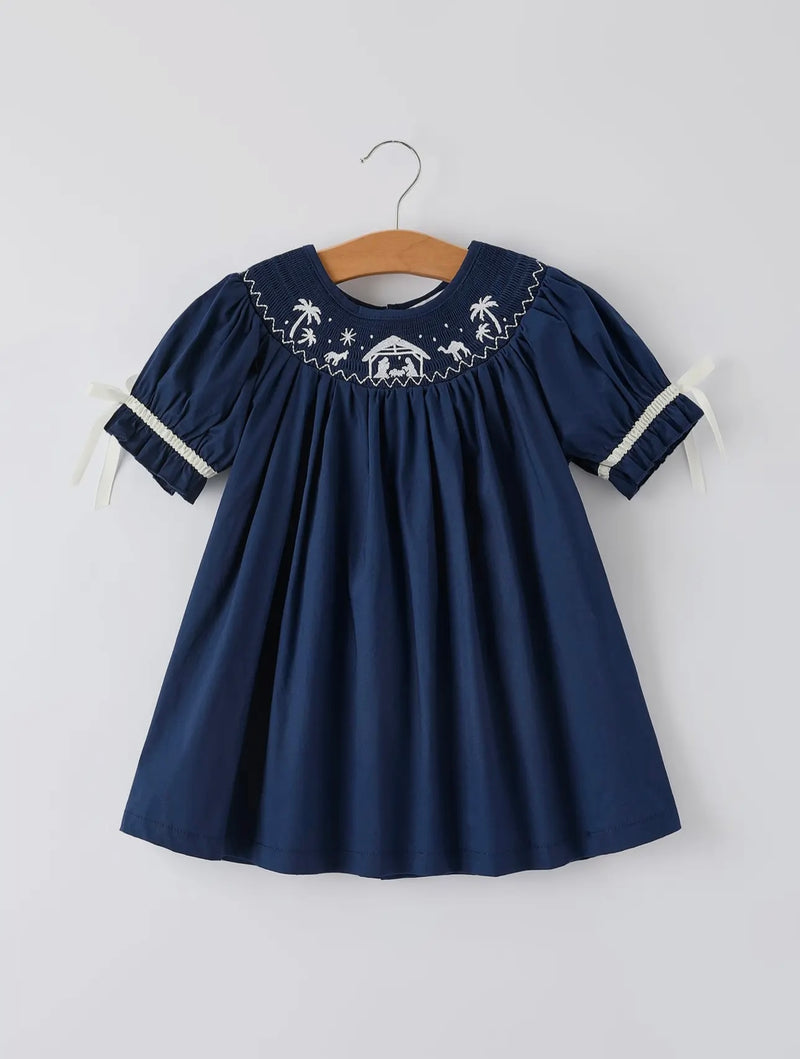 Navy blue dress with white embroidery on a hanger against a white background