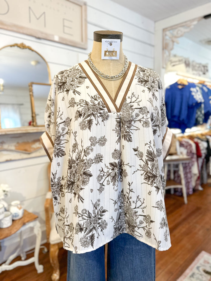 Floral blouse on a mannequin in a store setting