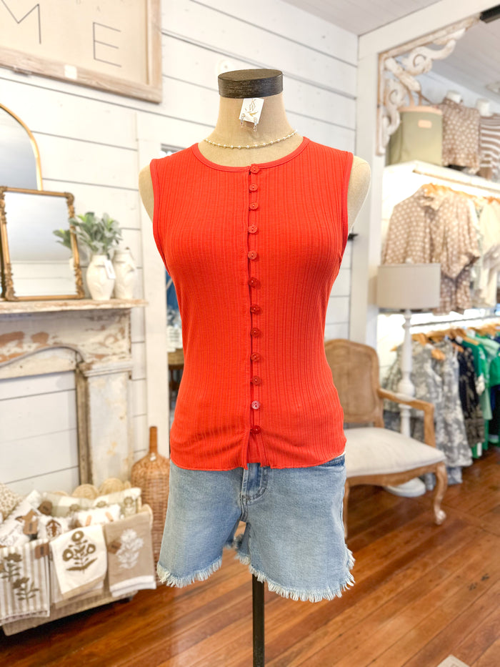 Mannequin wearing a red sleeveless top and denim shorts in a store setting.