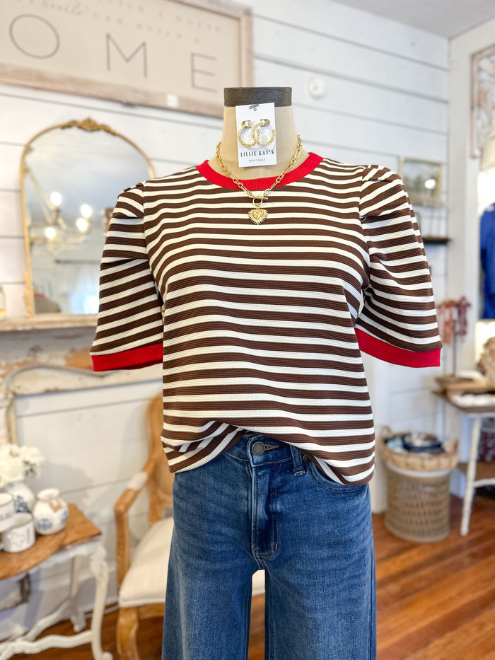 Mannequin wearing a striped shirt and jeans in a store setting