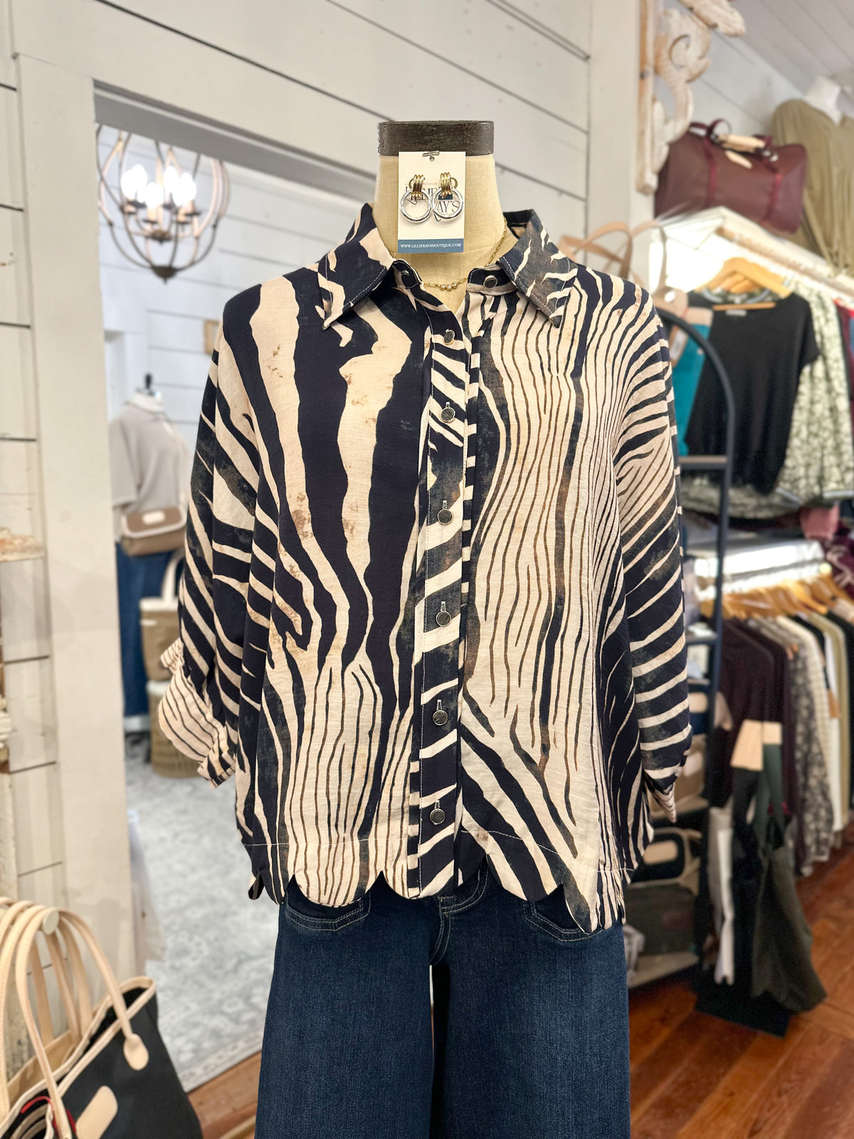 cream and navy button down blouse in store setting 