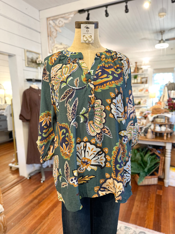 Mannequin wearing a patterned blouse in a store setting umgee print top 