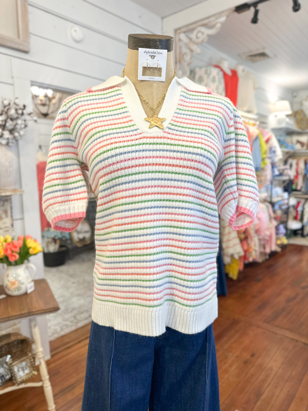 Colorful striped sweater on a mannequin in a store setting