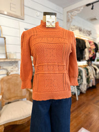 Orange sweater on a mannequin in a store setting