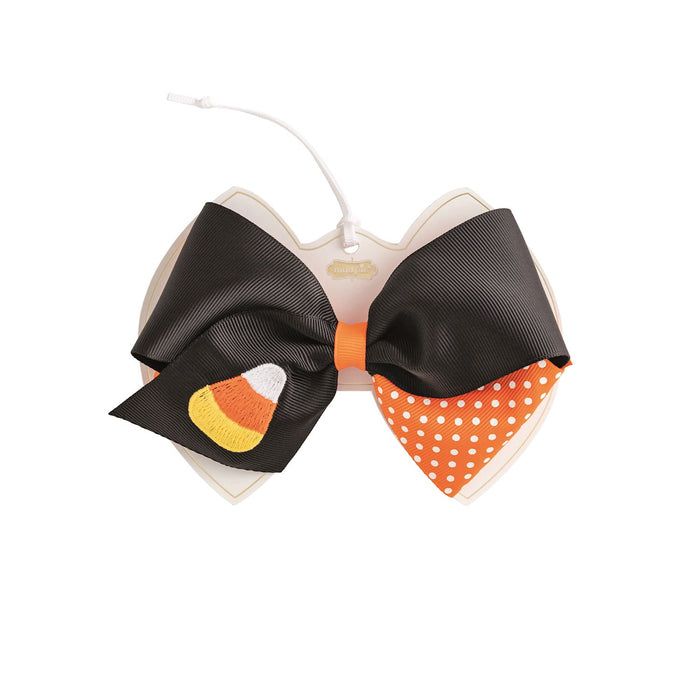 Black and orange bow with candy corn design on a white background