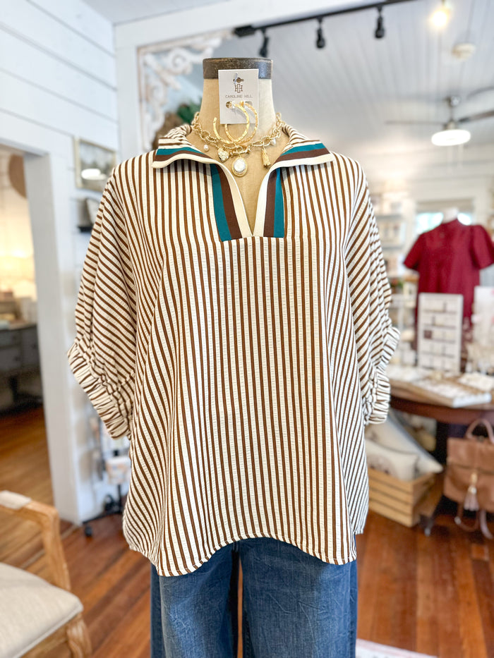 brown and cream Striped shirt on a mannequin in a store setting