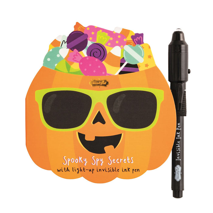 Pumpkin-shaped notebook with sunglasses and a light-up invisible ink pen on a white background