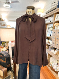 brown fall blouse with buttons down the front and tie around neck to make a bow
