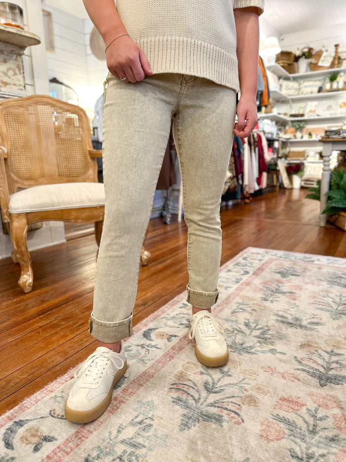 Person wearing beige pants and white sneakers in a store setting