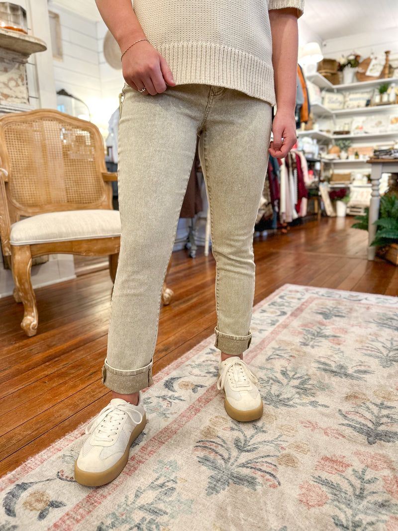 Person wearing beige pants and white sneakers in a store setting