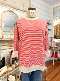 Red and white striped shirt on a mannequin in a store setting