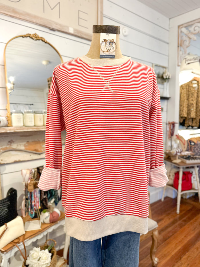 Red and white striped shirt on a mannequin in a store setting