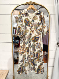 Patterned dress hanging on a mirror with a wooden frame.
