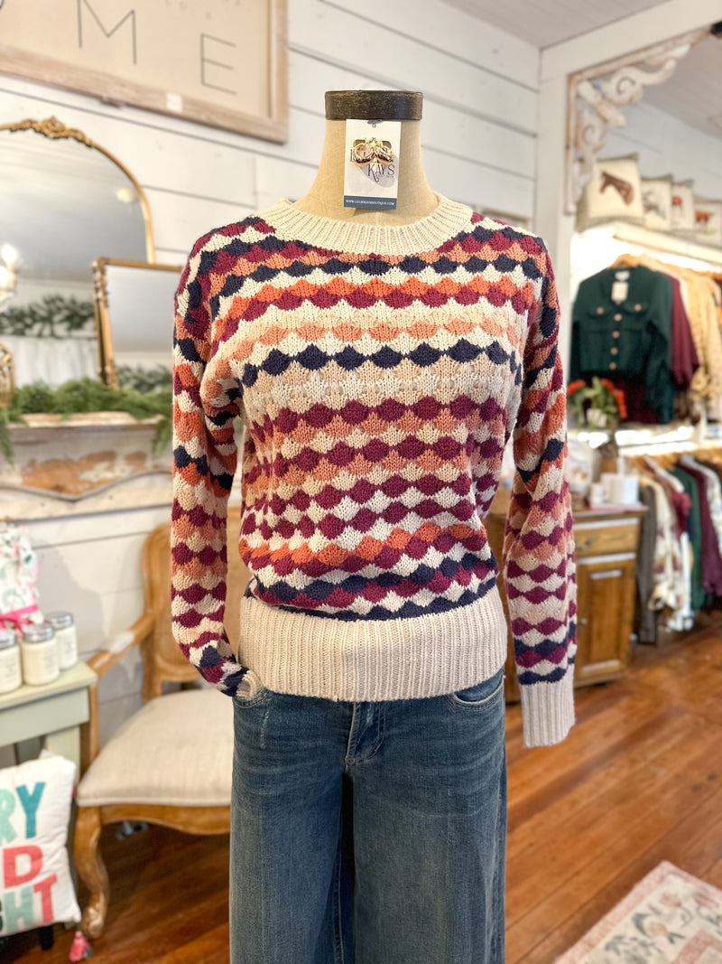 Multicolored patterned sweater on a mannequin in a store setting