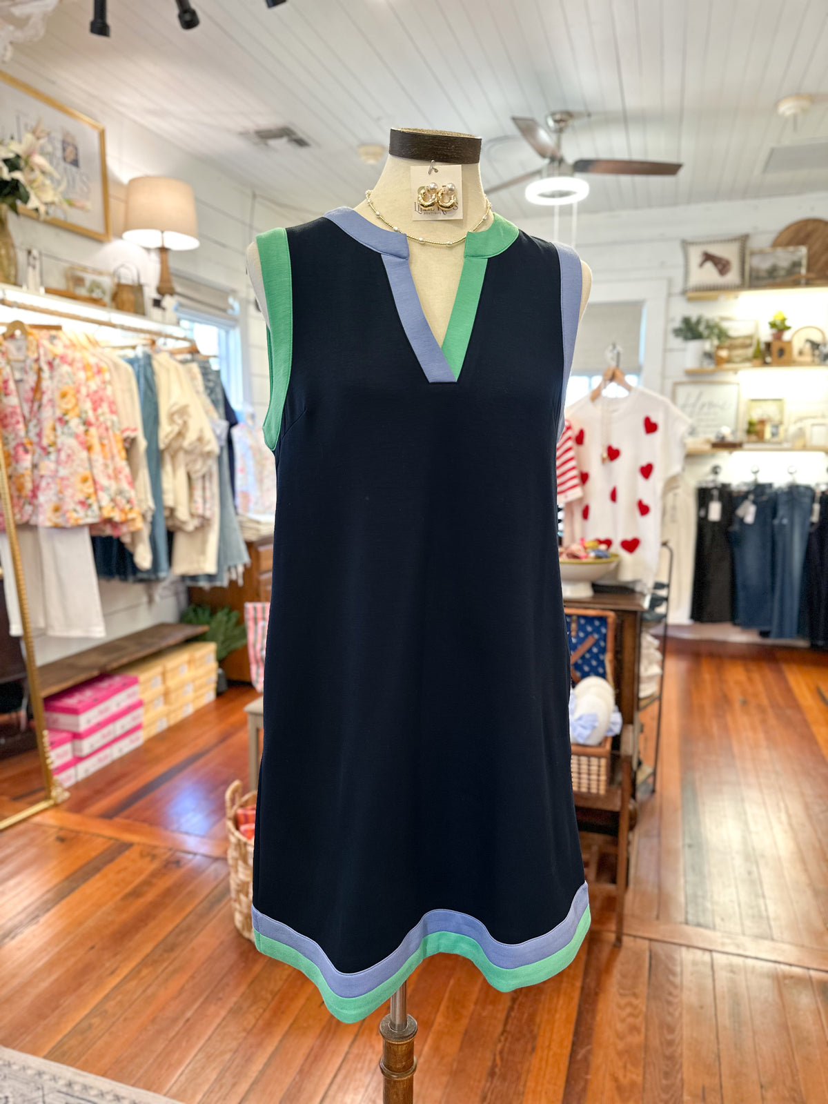 navy dress with colorful trim on a mannequin in a store setting