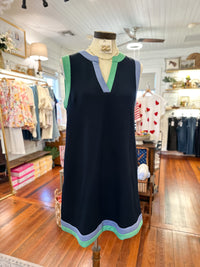 navy dress with colorful trim on a mannequin in a store setting