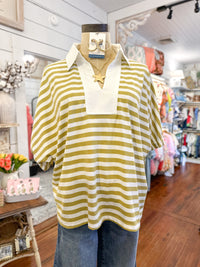 Yellow/green and white striped shirt on a mannequin in a store setting