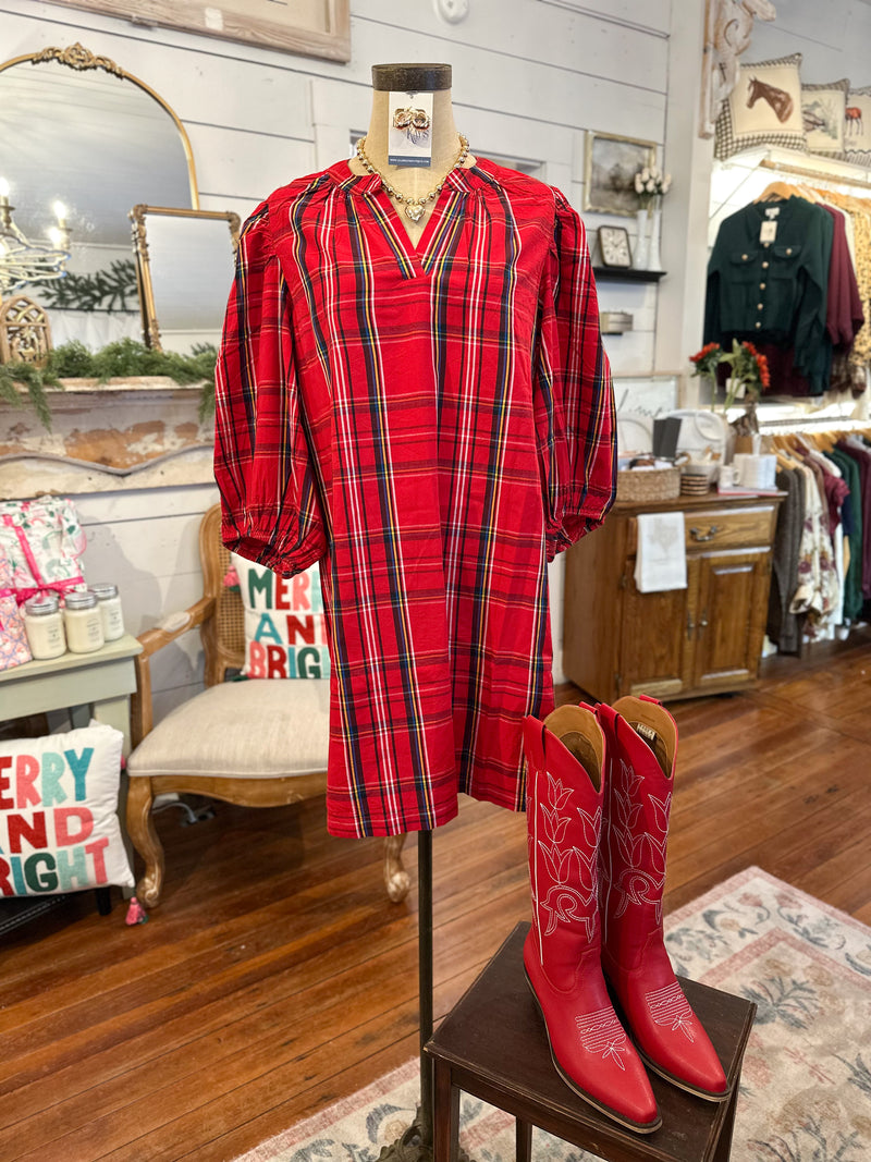 Red plaid dress on a mannequin with red cowboy boots in a store setting