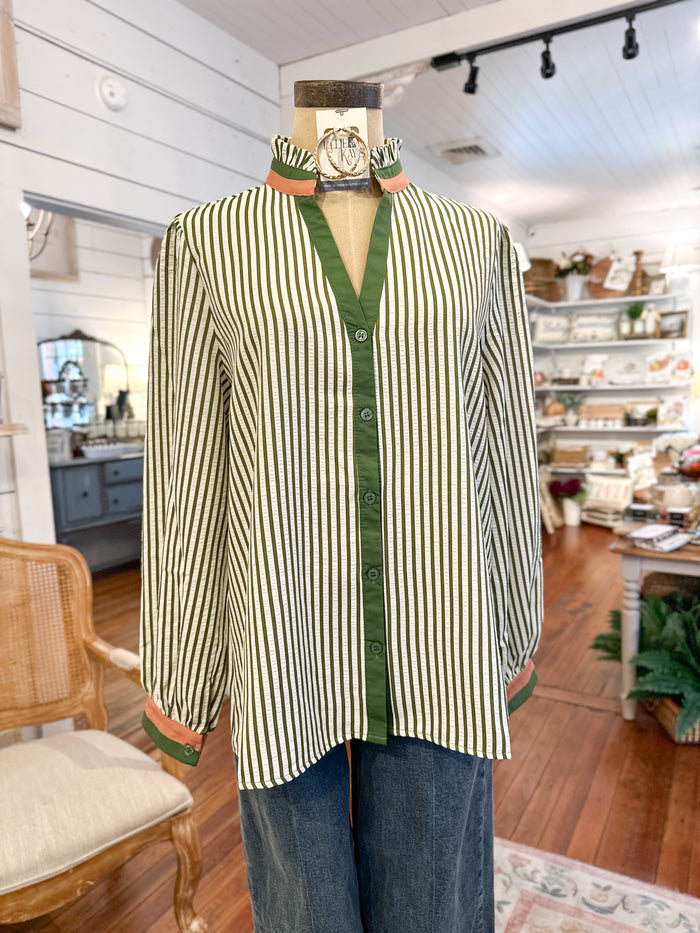 Striped shirt with green trim on a mannequin in a store setting
