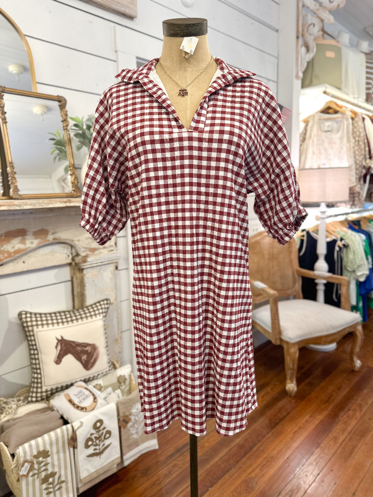 Maroon and white checkered dress on a mannequin in a store setting.