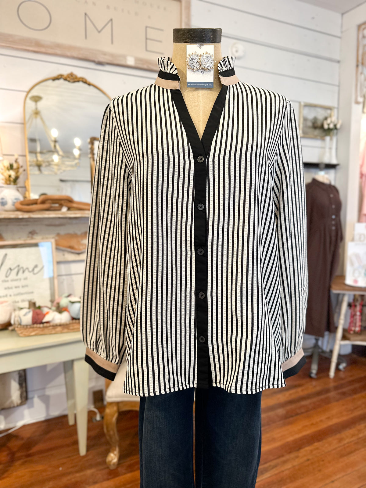 Mannequin wearing a black and white striped cardigan in a store setting