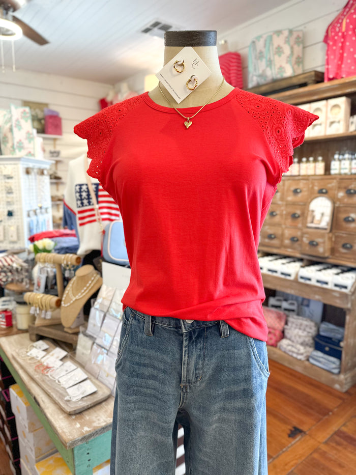 Mannequin wearing a red top and blue jeans in a store setting