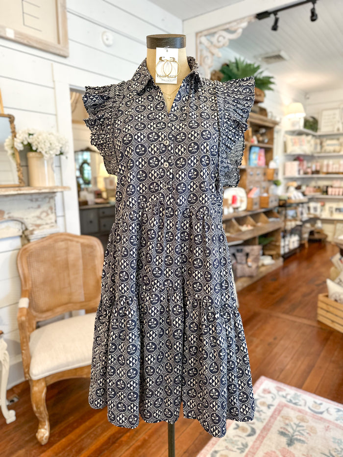 Patterned navy and cream dress on a mannequin in a store setting