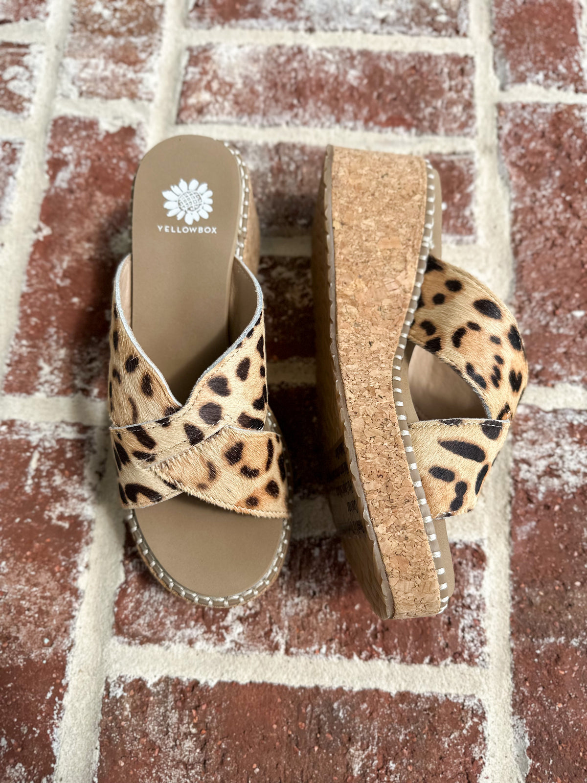 Leopard print sandals on a brick surface