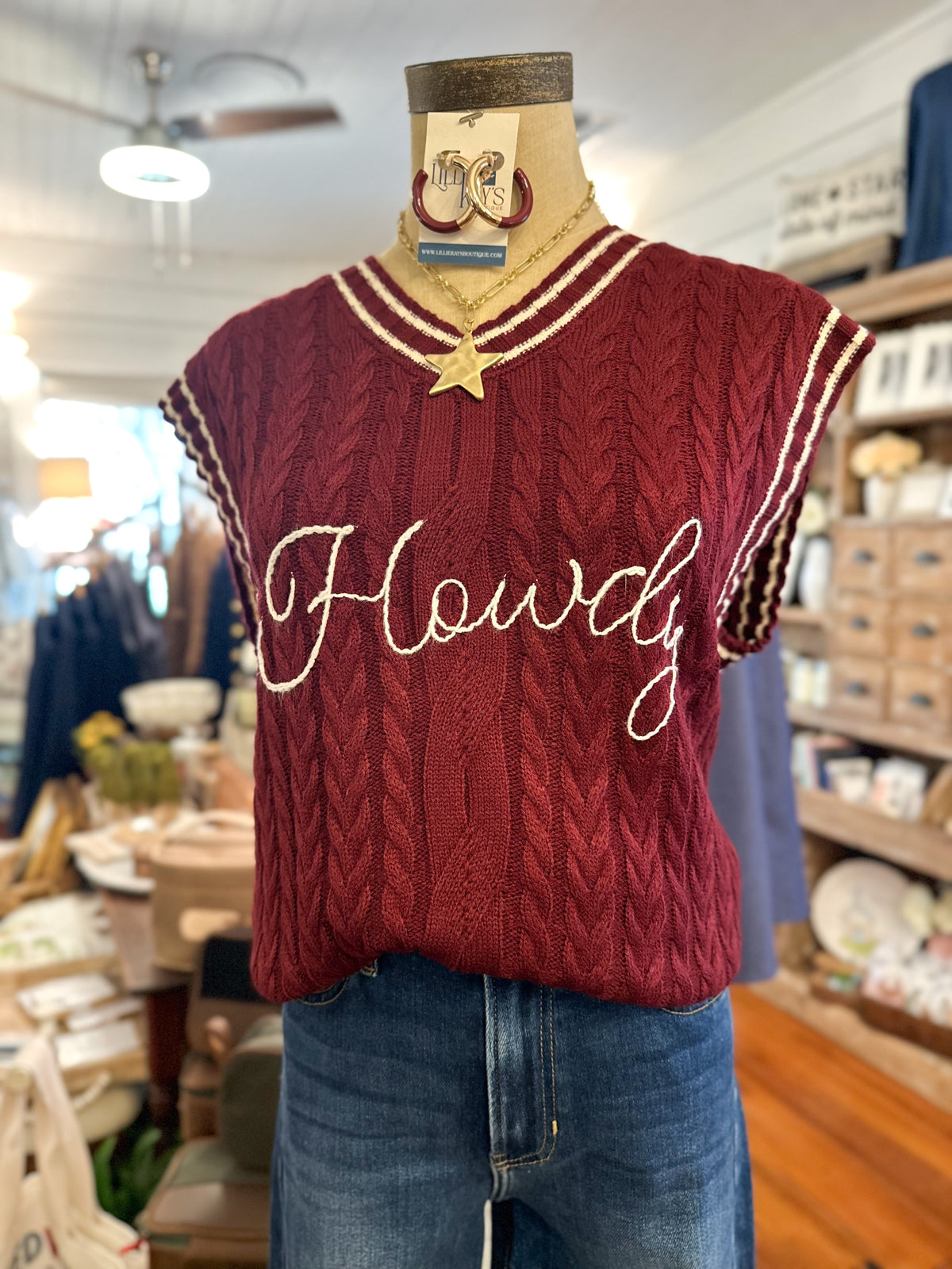 howdy maroon vest with denim jeans in store setting 
