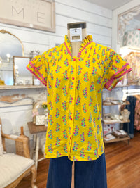 Yellow patterned shirt on a mannequin in a store setting