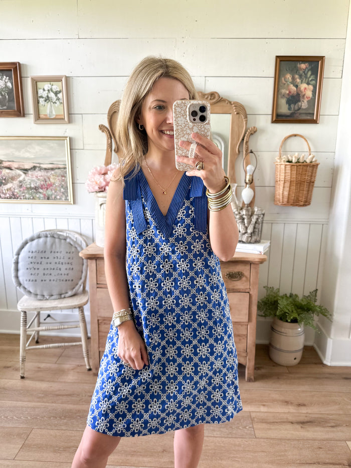 Woman taking a mirror selfie wearing a blue dress in a home setting. royal blue eyelet lace details 