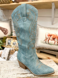 Blue cowboy boot with intricate designs on a wooden surface.