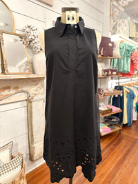 Black sleeveless dress with cut-out details on a mannequin in a store setting.