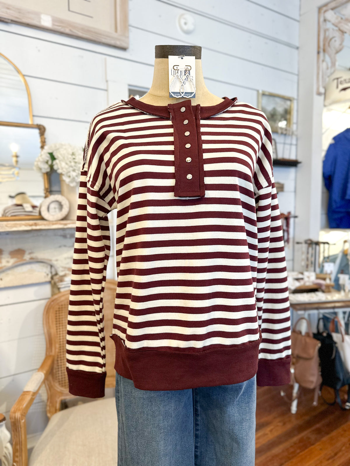 Striped sweater on a mannequin with a tag in a store setting