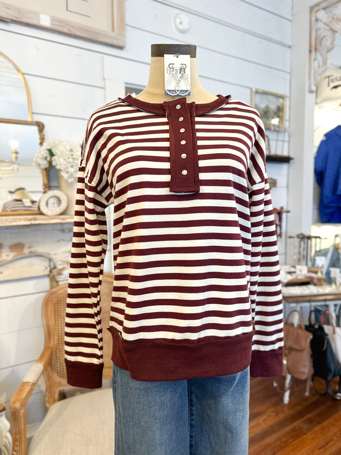 Striped sweater on a mannequin with a tag in a store setting