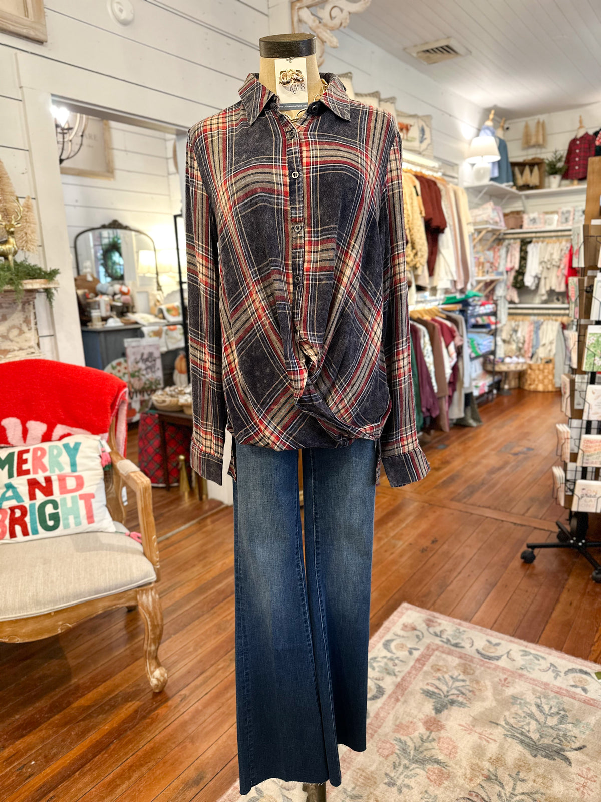 Plaid shirt and jeans on a mannequin in a store setting with furniture and decor.