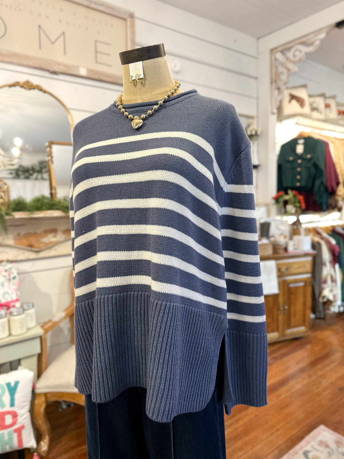 Mannequin wearing a blue and white striped sweater in a store setting