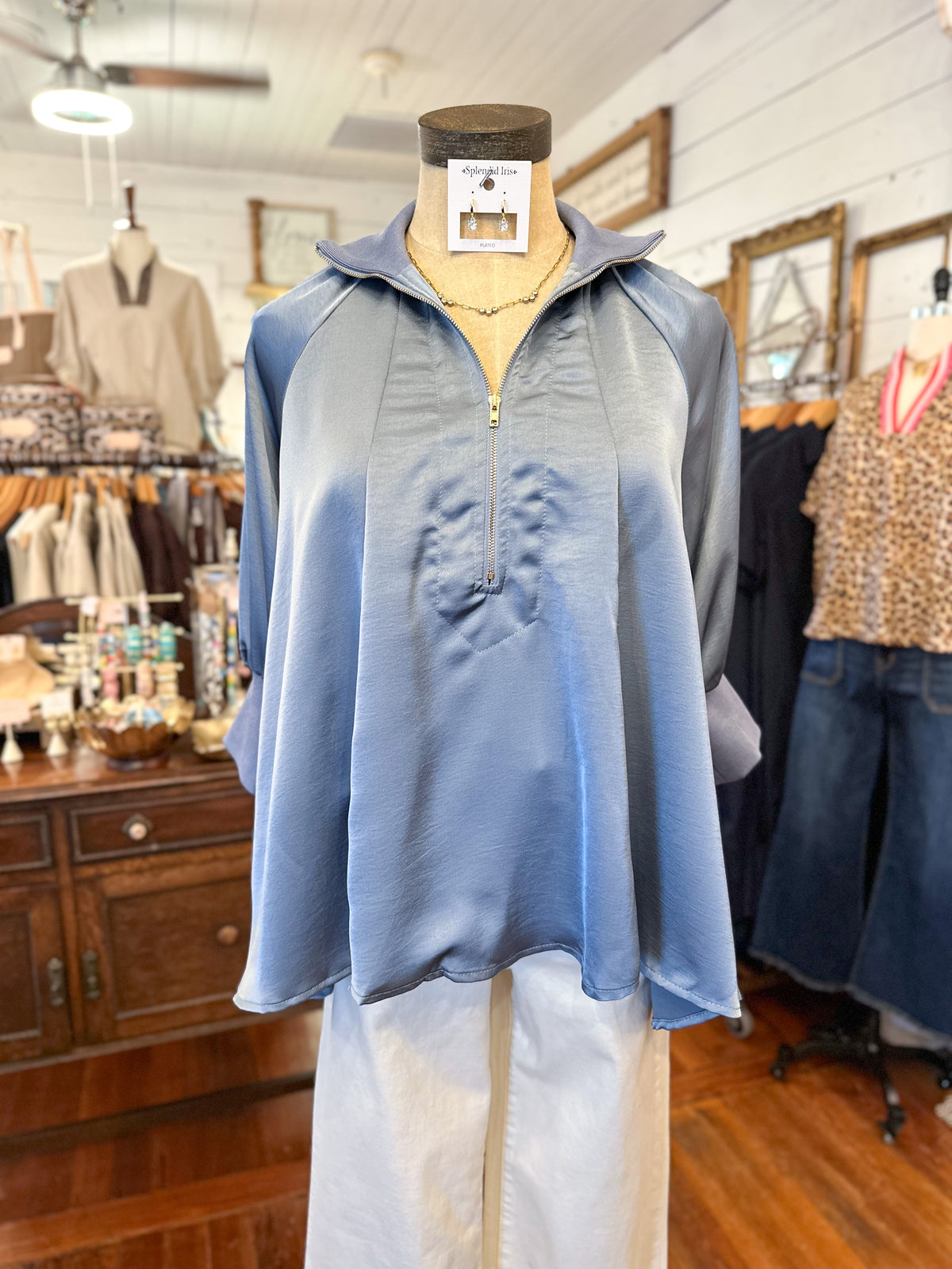 Slate Blue satin 3 quarter sleeve top with high neckline in store setting