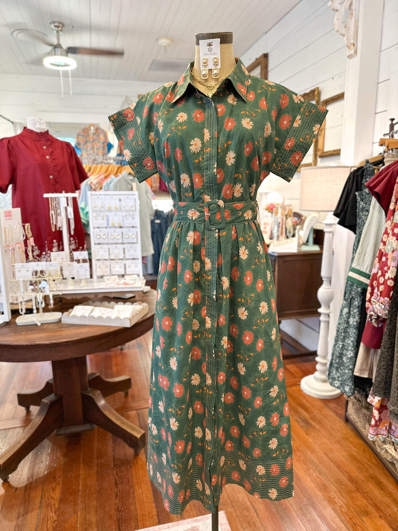 Green floral dress on a mannequin in a store setting