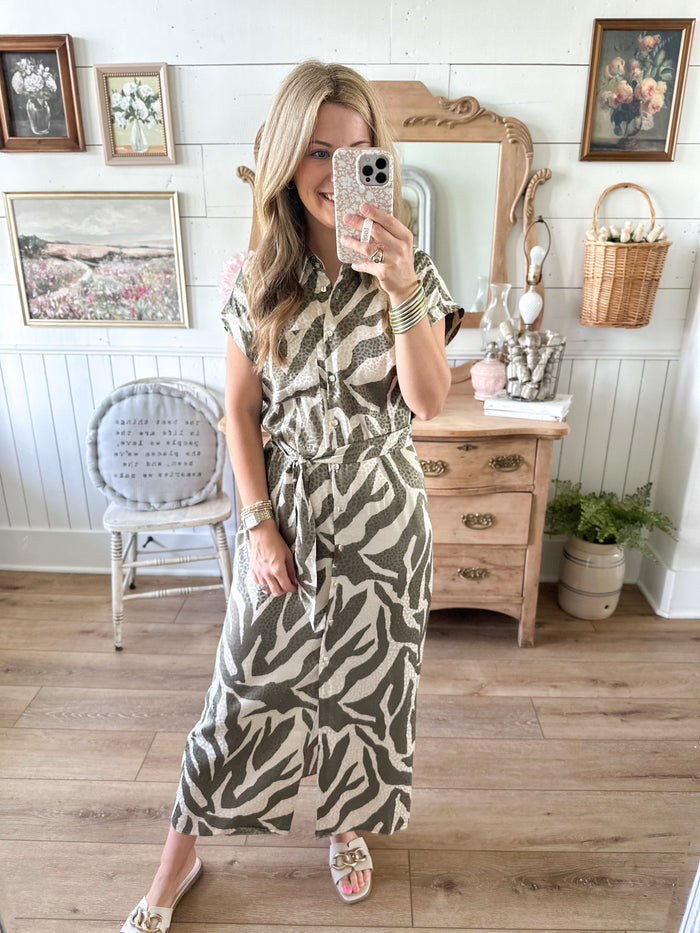 Woman taking a mirror selfie wearing a patterned dress in a home setting.