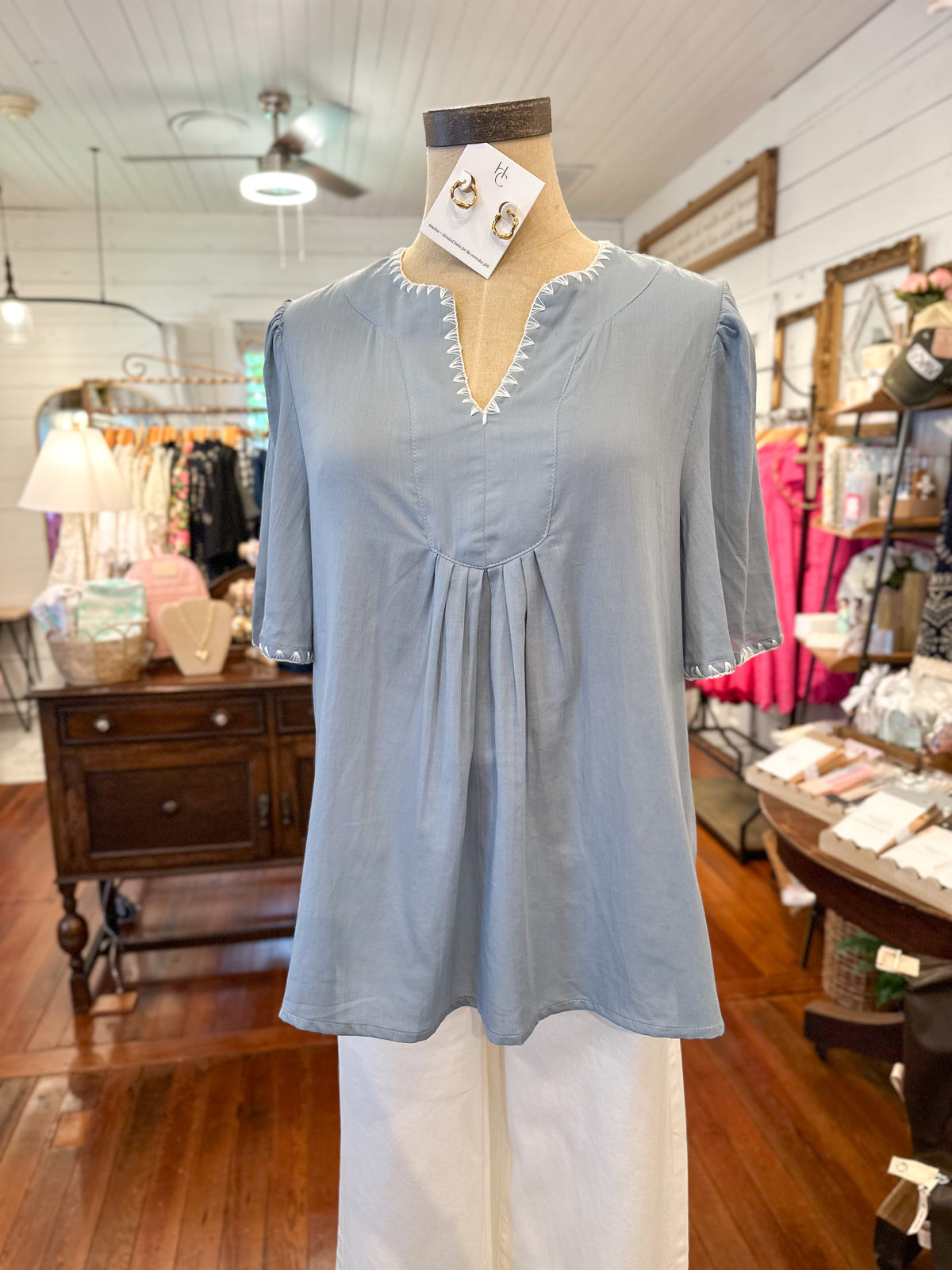 Light blue blouse on a mannequin in a store setting