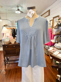 Light blue blouse on a mannequin in a store setting