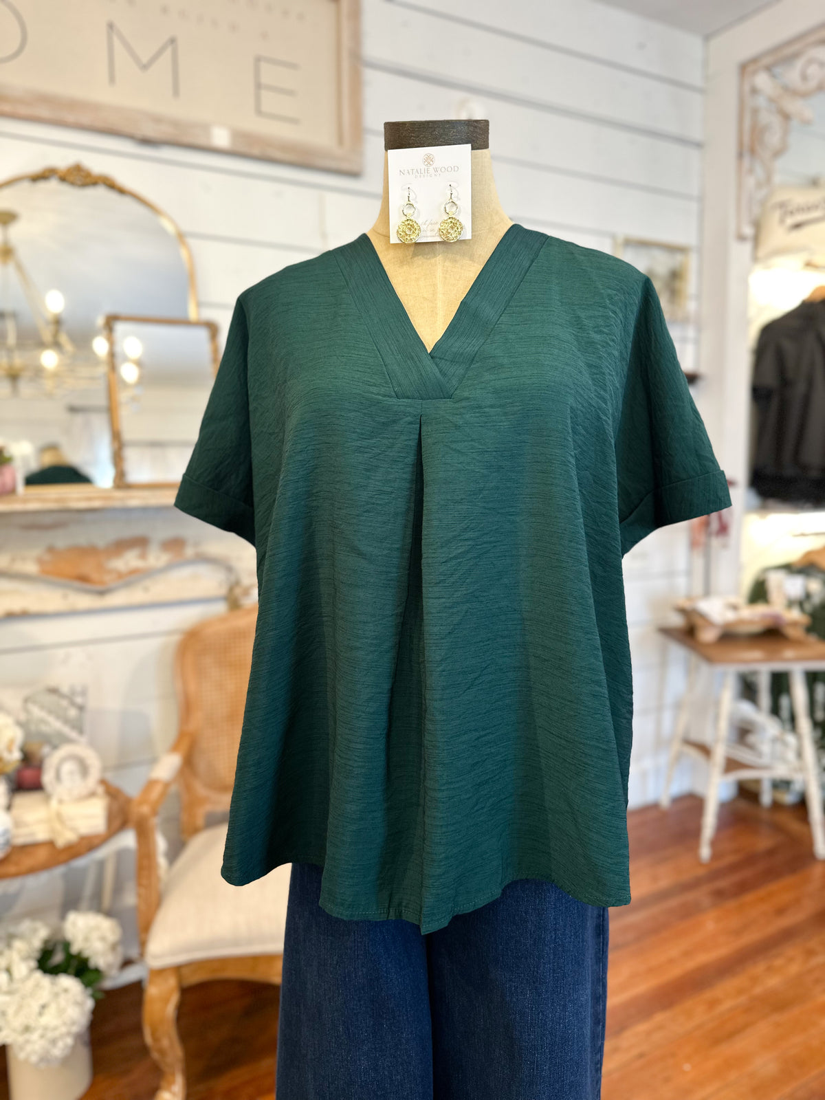 Green blouse on a mannequin in a store setting