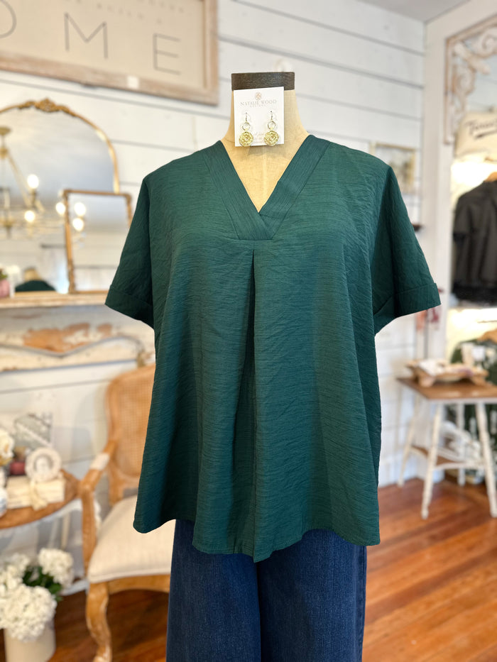 Green blouse on a mannequin in a store setting