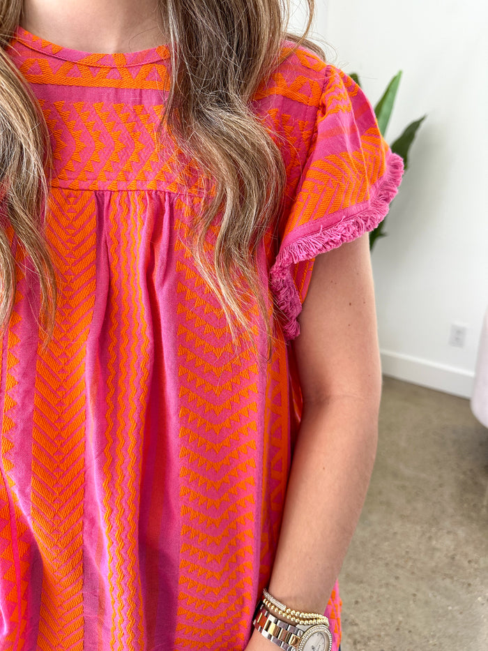 pink and orange embroidered top with flutter sleeves 