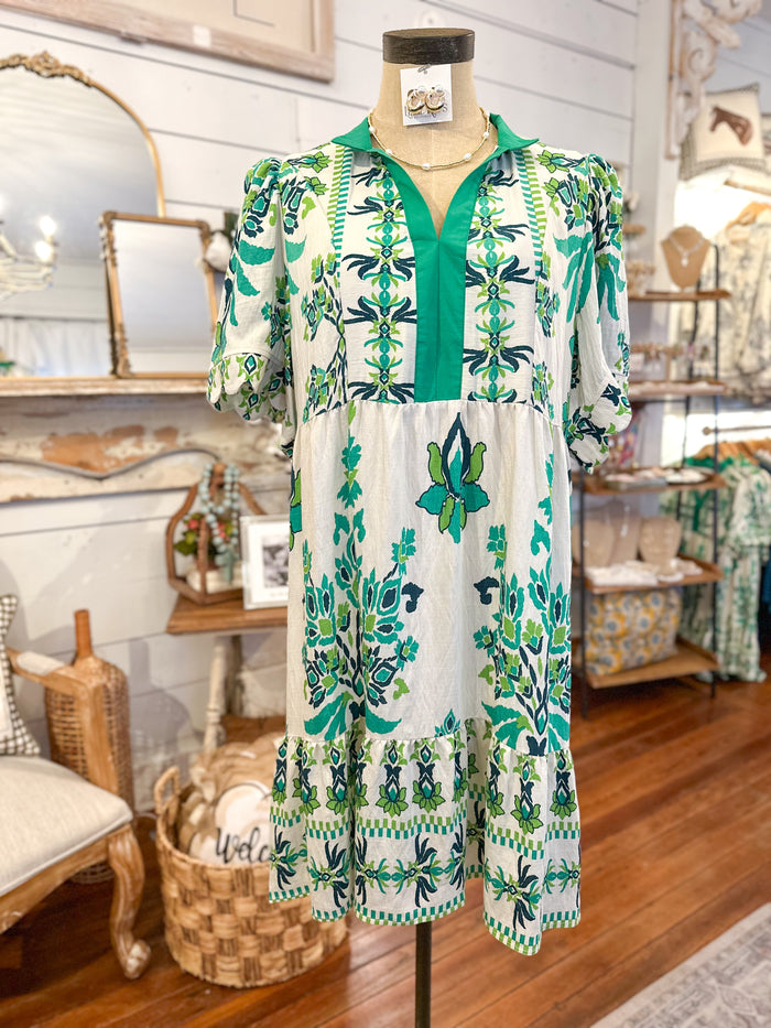 Green and white floral dress on a mannequin in a store setting