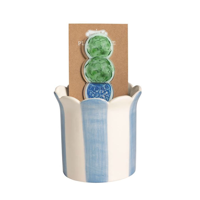 Decorative vase with blue and white design, featuring a cardboard backing with green and blue circular patterns. mud pie 