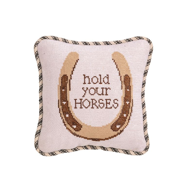 Decorative pillow with a horseshoe design and 'hold your horses' text on a white background