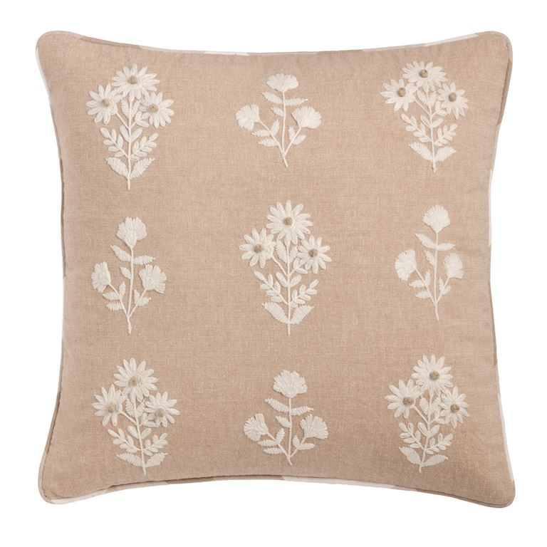 Beige pillow with white floral patterns on a beige background